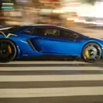 A blue sports car driving down a city street